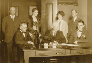 Tennessee Governor Austin Peay signs legislation authorizing purchase of Little River Company land, a key victory in the creation of Great Smoky Mountains National Park. Standing second from left is Representative Anne M. Davis. Photo provided by GSMNP archives. 