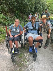 From left, ADA coordinator for Knox County and volunteer for Catalyst Sports Carly Pearson, program participant Cecil Williams, and Park Ranger Katie Corrigan smile during an adaptive outing at Hazel Creek. Photo provided by Catalyst Sports.