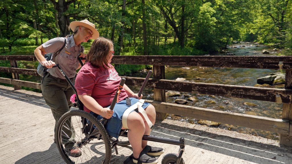 Katie Corrigan checks in with a program participant during a hike and boat tour at Hazel Creek this month. Photo provided by Jim Matheny, Friends of the Smokies.