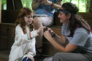 A girl gets a unique opportunity to see and touch a small songbird captured in a mist net in Great Smoky Mountains National Park. The park’s bird-banding program often leads to “magical” moments for children who participate, said Tremont Education Director John DiDiego. Photo provided by Erin Rosolina, Great Smoky Mountains Institute at Tremont. 