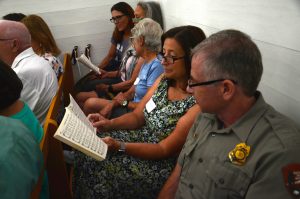 Smokies Acting Deputy Superintendent and Chief Ranger Boone Vandzura (right) and Friends of the Smokies President and CEO Dana Soehn share a hymnal during the reunion service in Palmer Chapel Methodist Church Sunday, August 11. Photo provided by Holly Kays, Smokies Life. 